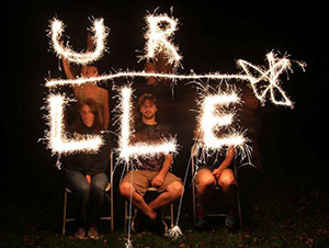 Graduate students creating URLLE logo with sparklers
