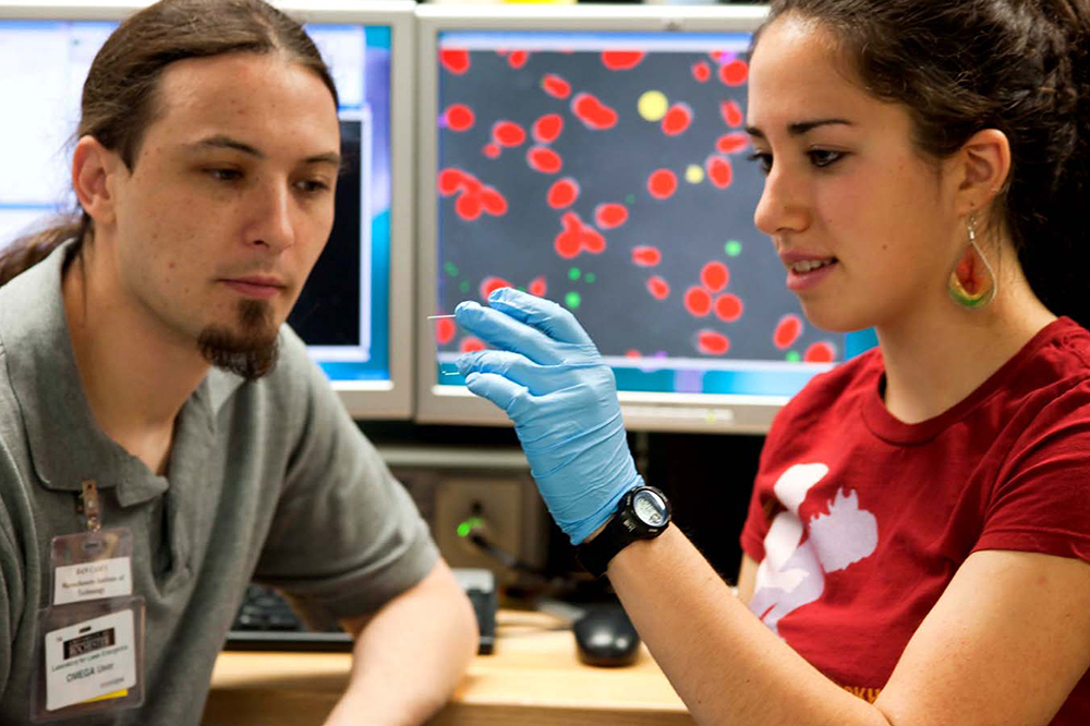 MIT graduate student Dan Casey with high school student in the lab