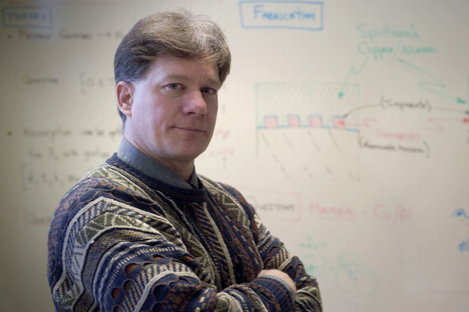 Photo of Terrance Kessler with equations on a whiteboard in background.