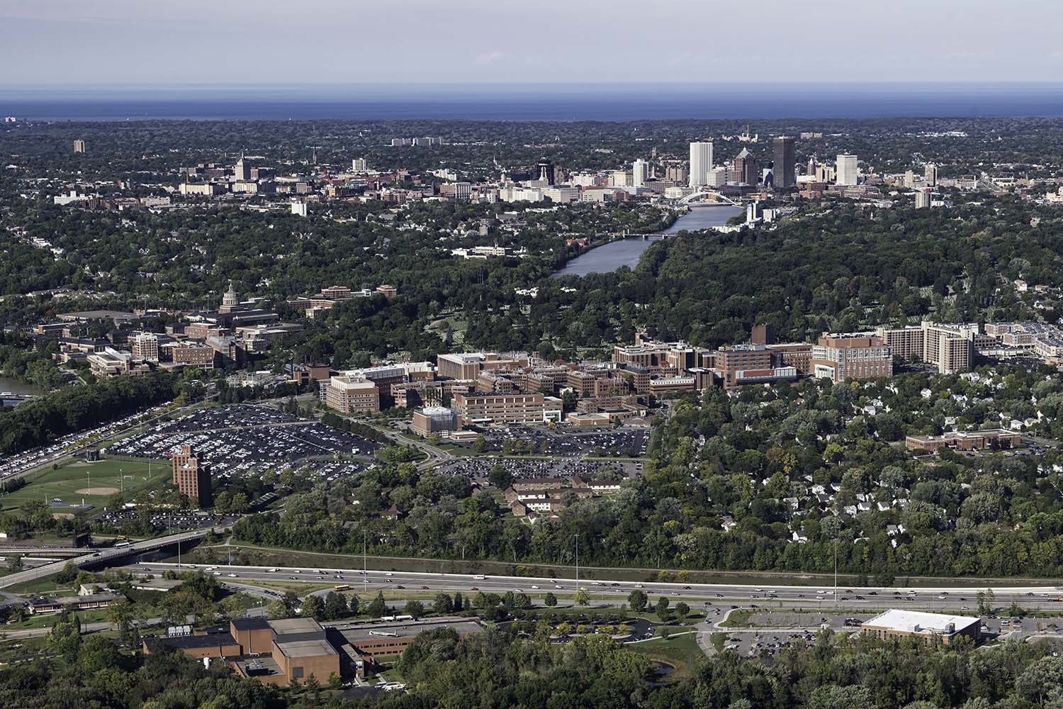 University of Rochester's Laboratory for Laser Energetics (foreground, left), URMC East River Road (foreground, rt) River Campus (center left ), Medical Center (center,) and downtown Rochester are seen alongside the Genesee River and Lake Ontario in aerial photos September 28, 2018. // Photo by J. Adam Fenster / University of Rochester