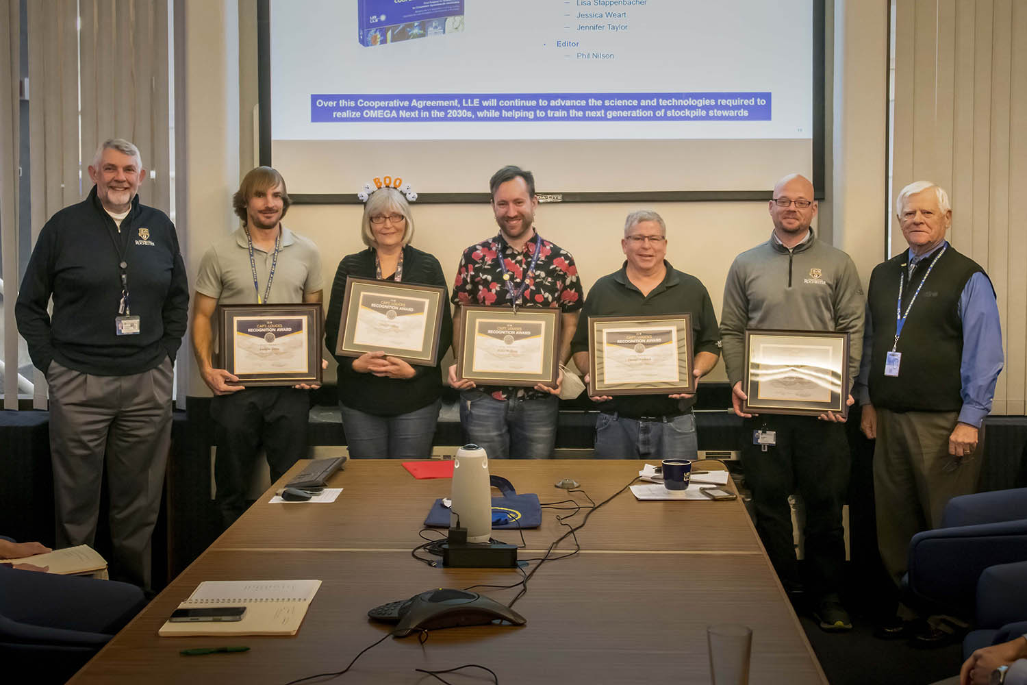 With LLE Director, Chris Deeney, on the left, and CAPT. Steve Loucks, on the right, shown holding their plaques which detail their recognition are from left to right Andrew Sorce, Sharyl Abbey, Tyler McKean, Daniel Neyland, and Jeremy Coon.
