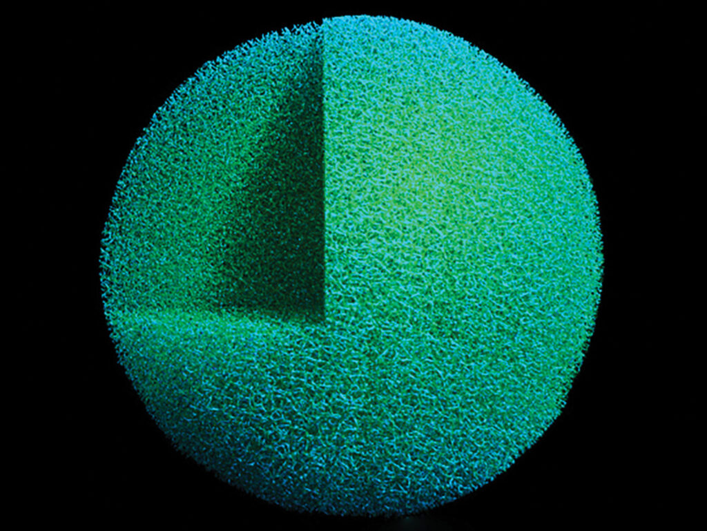 A close-up electron microscope image of a highly textured foam sphere, colorized in green and blue.