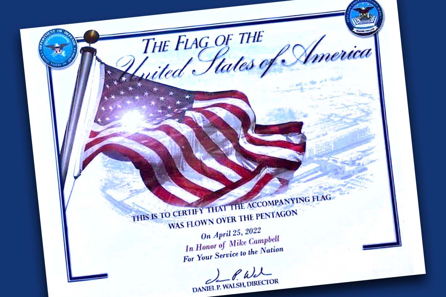 Certificate that reads: The Flag of the United States of America, this is to certify that the accompanying flag was flown over the Pentagon on April 25, 2022 in honor of Mike Campbell for your service to the Nation.