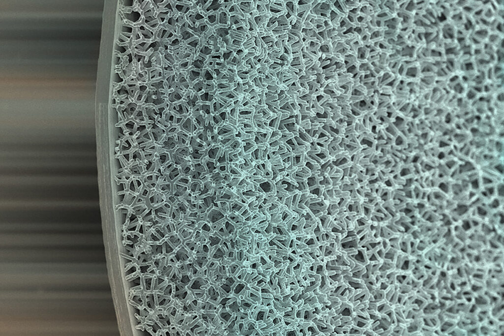 A magnified photgraph of the edge of a colorized foam hemishell showing the foam/ablator interface.
