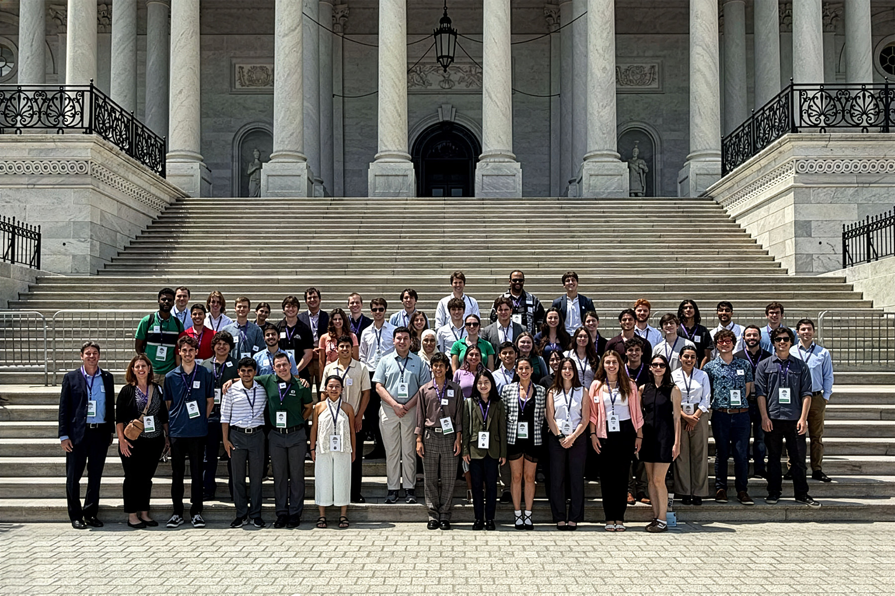 A ptograph of a large group of people posing on the steps of a capitol building.