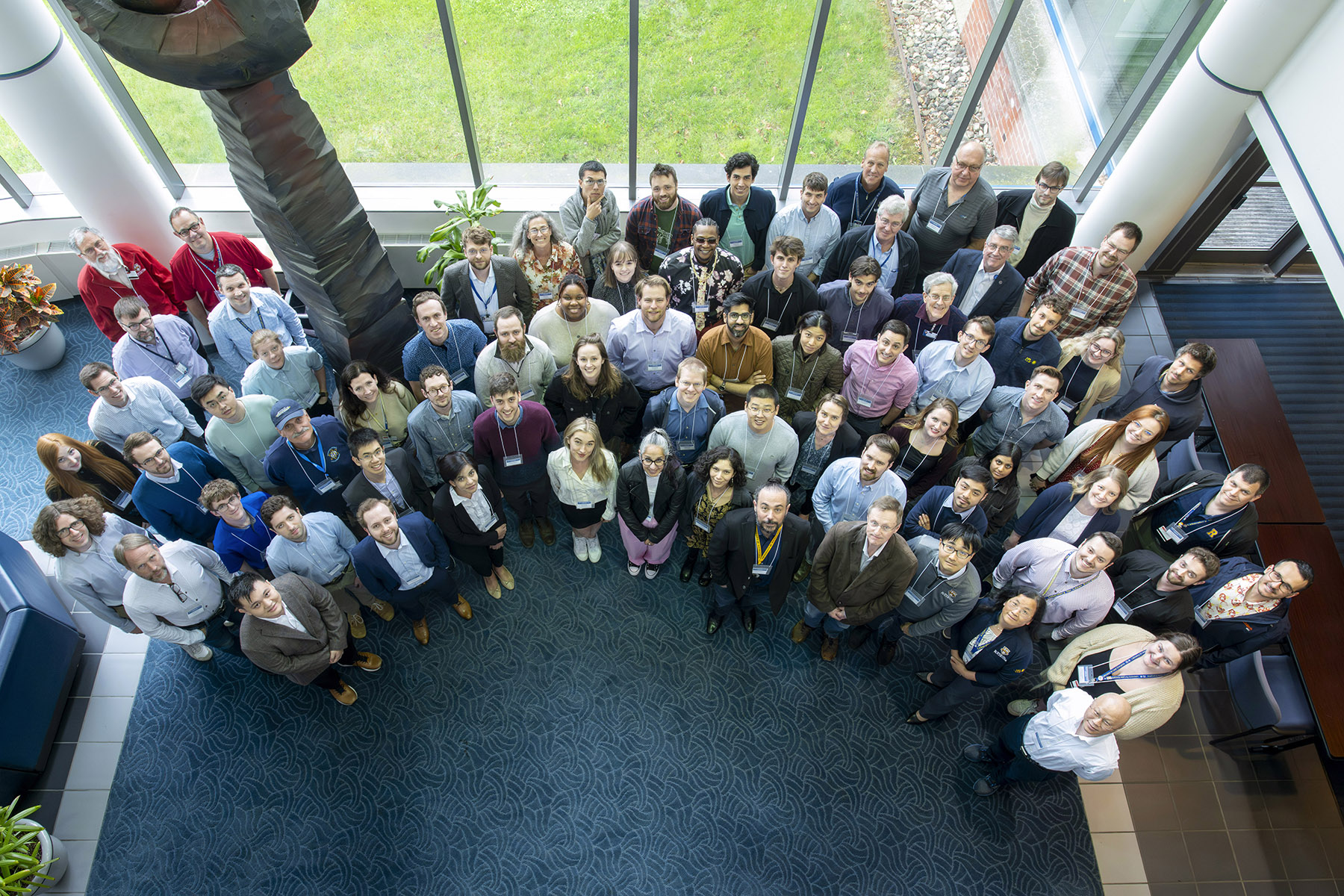 Group of all in-person OLUG attendees standing in the LLE East Lobby.