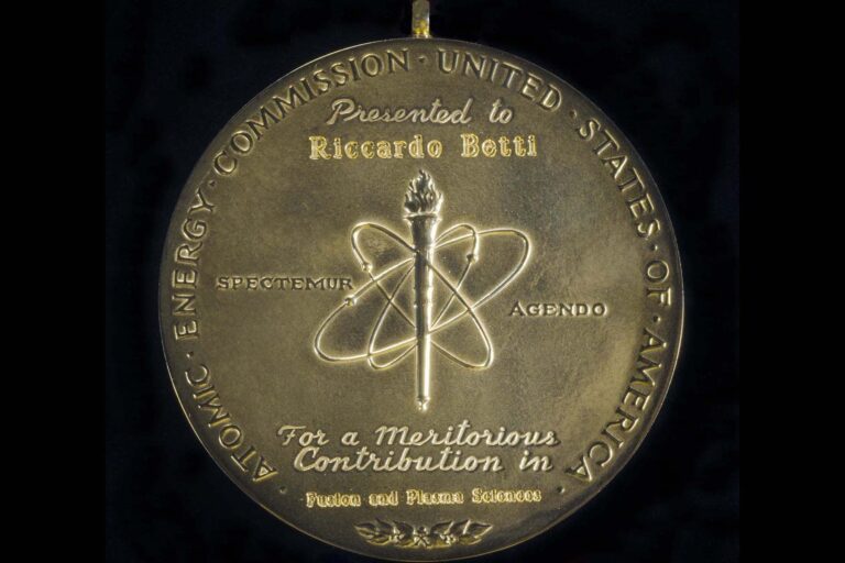 A gold medallion with engraved words. The medal reads, 