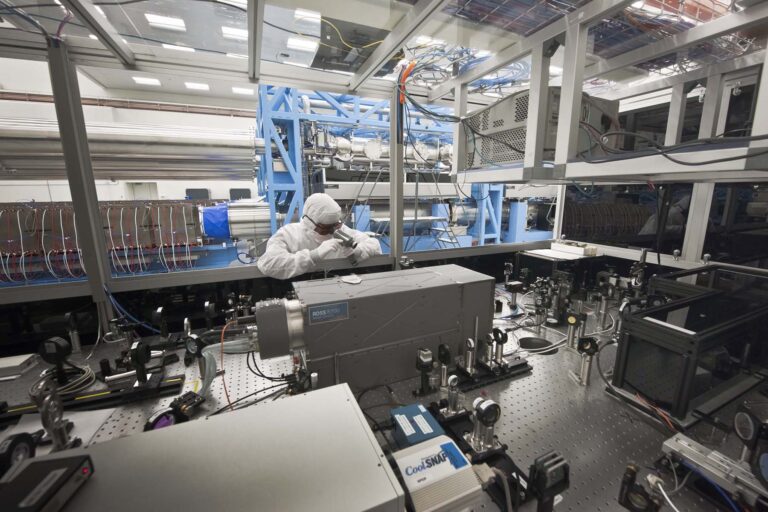 Photo of the UROSS camera inside teh OMEGA EP Laser Bay. A technician stands above the camera examining equipment.