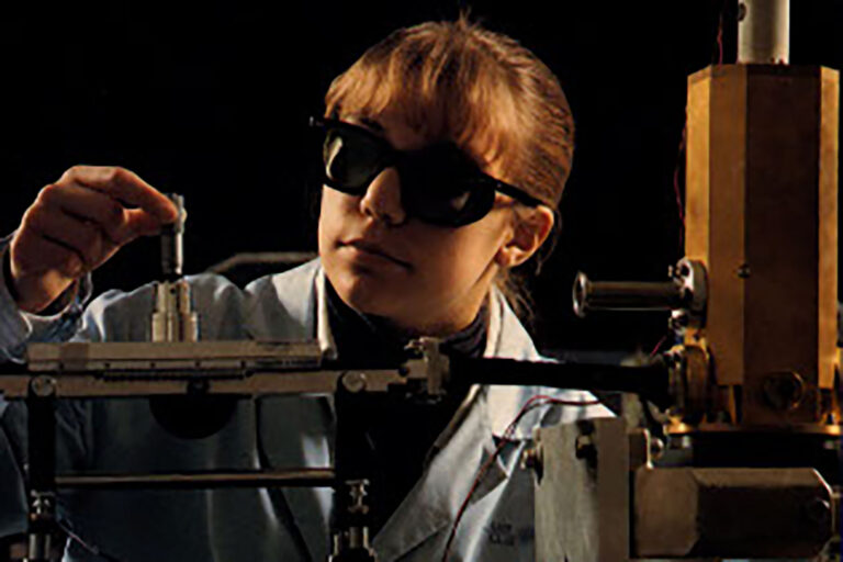 Andrea Huberty in a dark lab wearing dark safety glasses.
