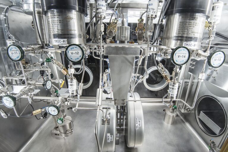 Stainless-steel laboratory setup with complex valves, gauges, and pressure systems used for precision research or cryogenic operations.