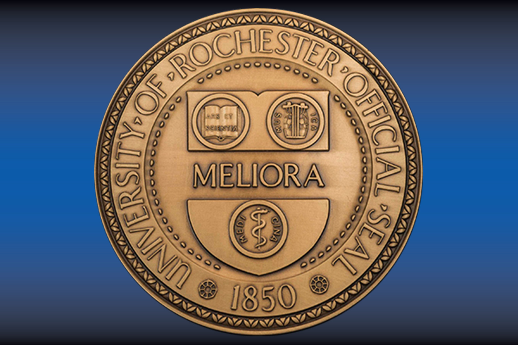 The official University of Rochester seal featuring the word “Meliora,” three symbols, and the founding year 1850, embossed on a gold medallion.
