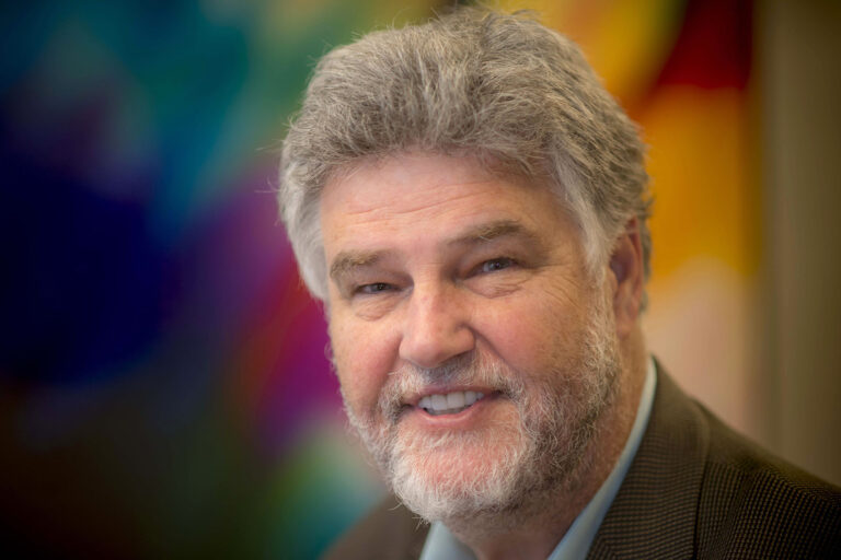 Portrait of man smiling with multicolor background.