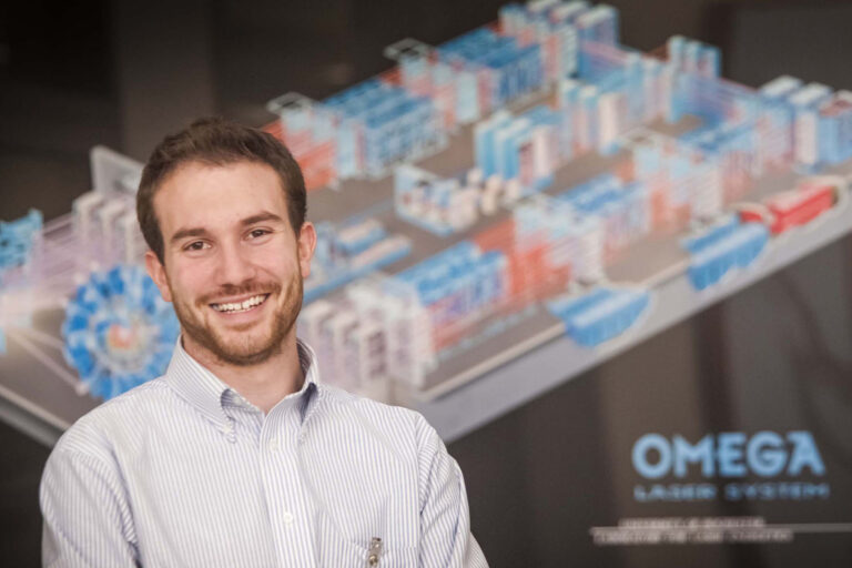 Portrait of person smiling in front of poster.