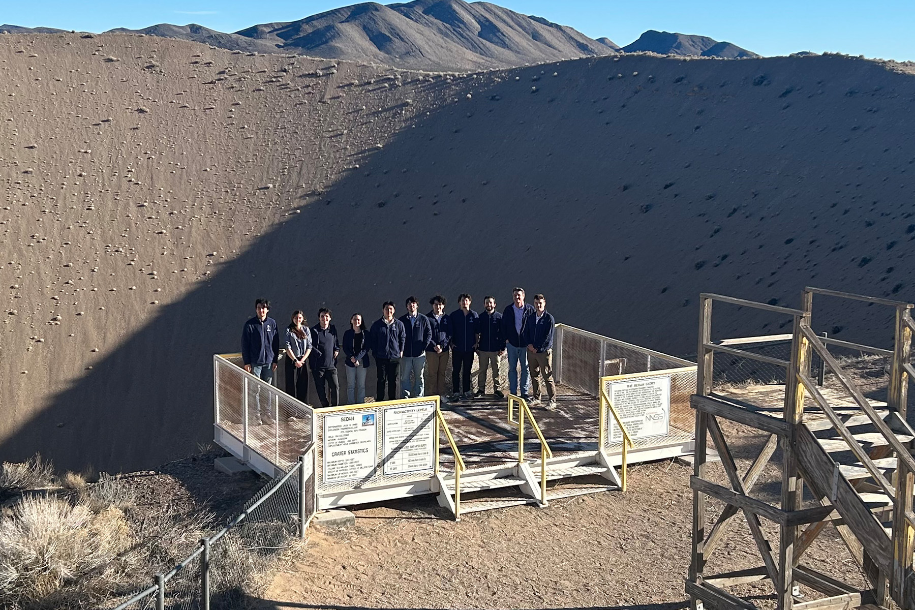 Students on a viewing platform in front of the largest man-made crater in the US.
