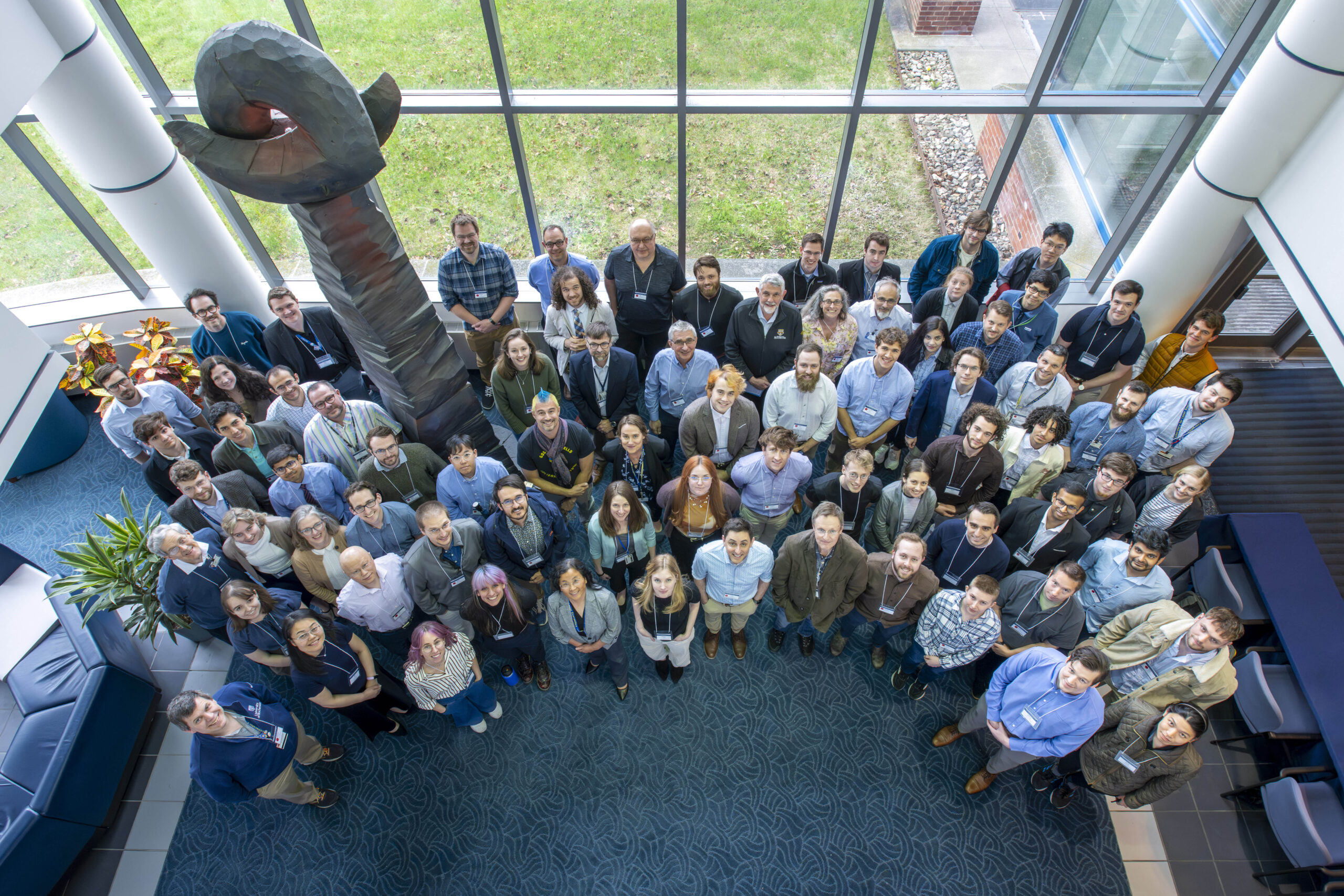 Group of all in-person OLUG attendees standing in the LLE East Lobby.