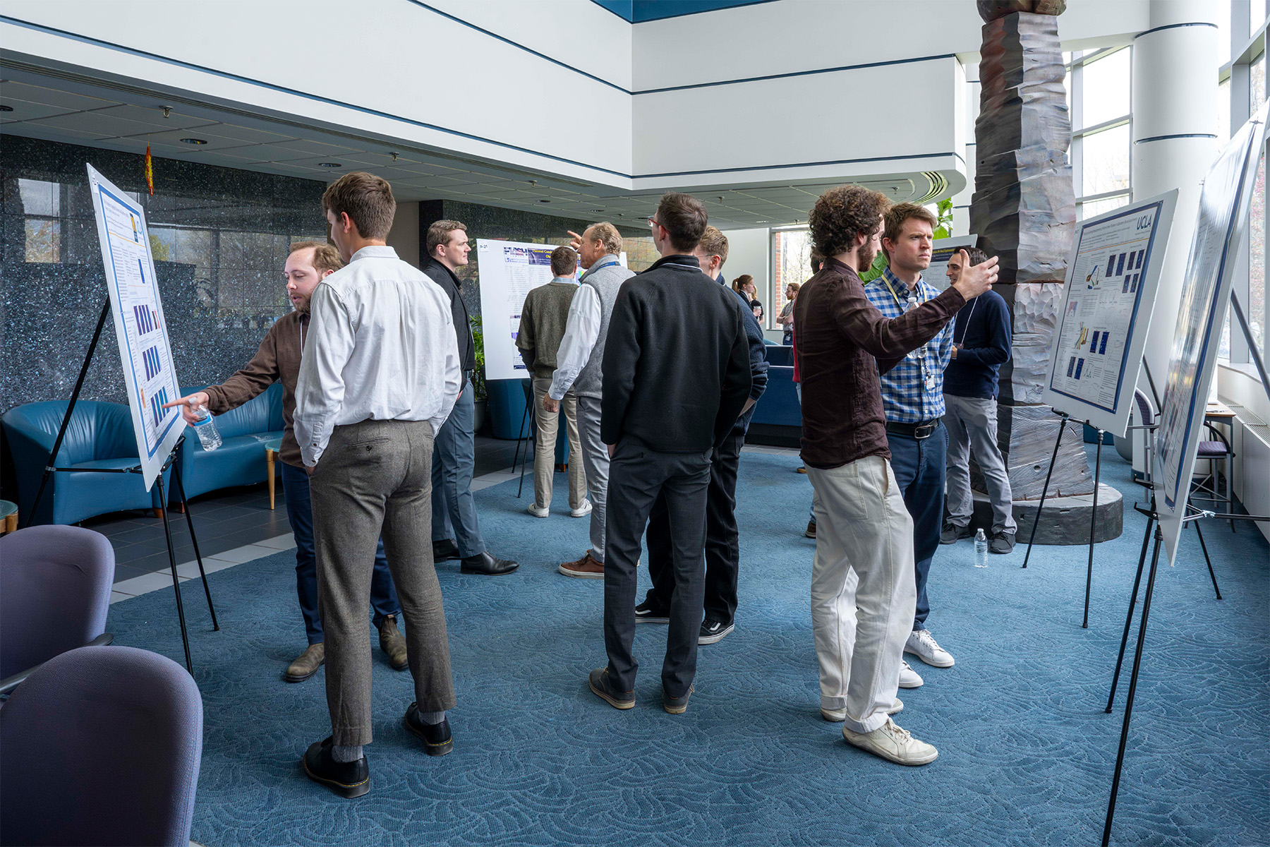Group of people with posters in the LLE's East Lobby.