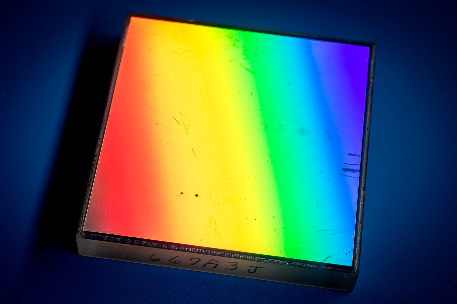 Grating showing rainbow prism on its surface.