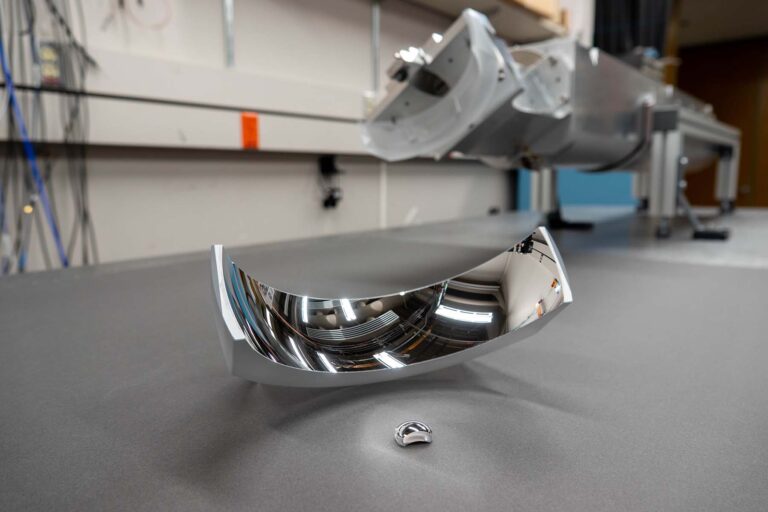 Mirrored curved parts on a table in the lab.